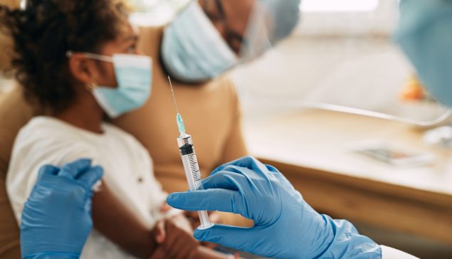 Close-up of doctor giving vaccine to a child at medical clinic.